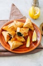 Arabic and middle eastern food concept. Fatayer sabanekh - traditional arabic spinach triangle hand pies on a white stone