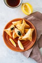 Arabic and middle eastern food concept. Fatayer sabanekh - traditional arabic spinach triangle hand pies dates and tea on a white