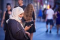 Arabic Middle eastern young woman wearing islamic scarf veil wearing a face mask under the chin, during covid 19 coronavirus