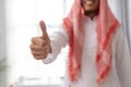 arabic muslim businessman standing showing thumb up