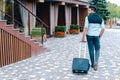 Young Guy Arab Businessman Student Came go to Restaurant With Suitcase in Hand, Smiling at Camera, Stops and Looks Away. Royalty Free Stock Photo