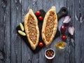 Arabic pizza Lahmacun on dark wooden background.