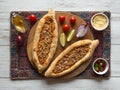 Arabic pizza Lahmacun on white wooden background.