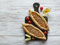 Arabic pizza Lahmacun on white wooden background.