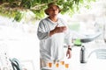 Arabic senior man talking and gesticulating near table with traditional tea.