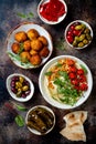 Arabic traditional cuisine. Middle Eastern meze with pita, olives, hummus, stuffed dolma, falafel balls, pickles.