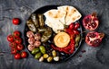 Arabic traditional cuisine. Middle Eastern meze platter with pita, olives, hummus, stuffed dolma, labneh cheese balls in spices. Royalty Free Stock Photo