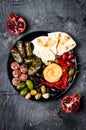 Arabic traditional cuisine. Middle Eastern meze platter with pita, olives, hummus, stuffed dolma, labneh cheese balls in spices. Royalty Free Stock Photo