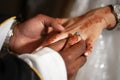 Man's hand slides diamond teardrop ring onto woman's finger. Royalty Free Stock Photo