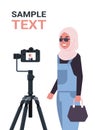 Arabic woman blogger recording video blog with digital camera on tripod live streaming social media blogging concept