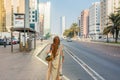 An Arabic woman wearing traditional clothes and hijab waiting for bus at the bus station of Abu Dahbi, United Arab Emirates