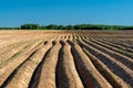 Arable land ploughed field. Cultivated land and soil tillage. Simple country landscape with plowed fields and blue skies