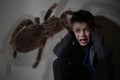 Arachnophobia. Double exposure of scared little boy and spider