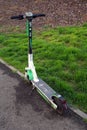 ARAD, ROMANIA, 20 April 2023: Green electric scooter parked on an alley in the park.