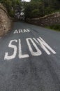 Araf, Slow, bilingual white warning on Welsh road.