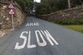 Araf, Slow, bilingual white warning on Welsh road.