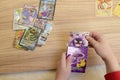 A child\'s hands placing rare collectible Pokemon trading cards on a wooden table