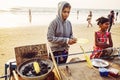 Indian woman preparing roasted sweet yellow corn at the beach