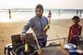 Indian woman preparing roasted sweet yellow corn at the beach