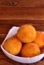 Arancini balls on a plate. Homemade dinner fried rice cutlets recipe. Close-up. Brown wooden background Royalty Free Stock Photo