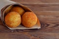 Arancini rice balls. Fried rice balls in paper on brown wooden background. Snack, street food Royalty Free Stock Photo