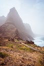 Aranhas mountain peak in the valley with house ruins and stony hiking path going up the mountain from Ponta do Sol to