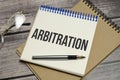 arbitration word on notepad and pen on wooden background