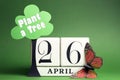 Arbor Day, plant a tree on April 26 with white block calendar, tree, butterfly and message against a green background.