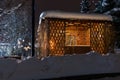 Arbor from a tree in the winter night with lighting. Beautiful wooden hut in winter time with trees and light. Royalty Free Stock Photo