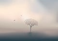 At dawn, two birds fly over a tree in the middle of a landscape drowned in mist. Royalty Free Stock Photo