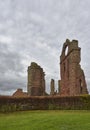 Arbroath Abbey Ruins under a darkening sky with rain beginning to fall.