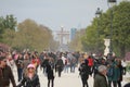 Crowded walking path in the park and in the background the Triumph Arc in Paris, France