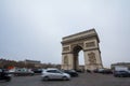 Arc de Triomphe triumph Arch on place de l`Etoile with a traffic jam of cars in front.