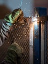 Arc welder worker in protective mask welding metal construction