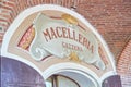 Arcade in red bricks around Sanctuary of Vicoforte church, ancient butchery sign in Italy