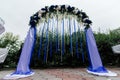 Arch with blue, white flowers, greenery and blue ribbons