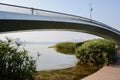 Arch bridge with jogging girl above planked path over lake in af