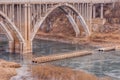 Arch bridge with spandrel columns spanning a river Royalty Free Stock Photo