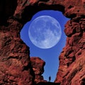 Arch in Canyon Red Rock Formations Silhouette of Hiker with Full Moon in Sky