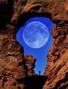 Arch in Canyon Rock Formations Silhouette of Hiker with Full Moon in Sky