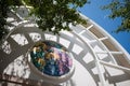 Arch casts shadow on round mosaic with christian saints above entrance to church in modern architectural style