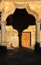 Arch and column of the cloister of the University of Salamanca with its shadow on the wall creating a cup shape in the hallway due