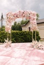 Arch decorated with flowers at the wedding caremony. Roce and gold color. Roses