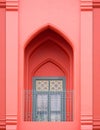 Arch door in Moroccan style with wooden window and wrought iron fence on balcony of vintage old rose building in vertical frame Royalty Free Stock Photo