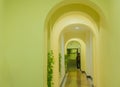 Yellow hotel corridor with many classical arches and decorative vines Royalty Free Stock Photo