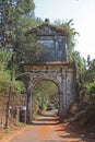 The Arch of the Immaculate Conception in Old Goa, India, is located above the road among trees and shrubs Royalty Free Stock Photo