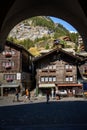 People on street with brown buildings in Zermatt, Switzerland