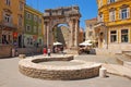 Arch of the Sergii with yellow building at Sergijevaca Ulica Street, an ancient Roman triumphal arch located in Pula, Croatia