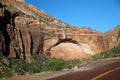 The arch shaped red mountain with the red paved road of Zion National Park Royalty Free Stock Photo