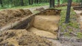 Archaeological excavation in a forest. A large plundering pit dug by archaeologist at an archaeological site